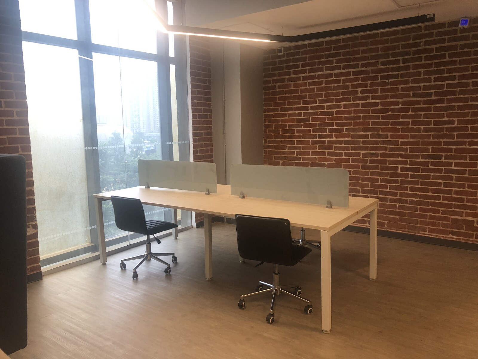 Cospaze Nikoo Homes — private desk with brick wall and city views